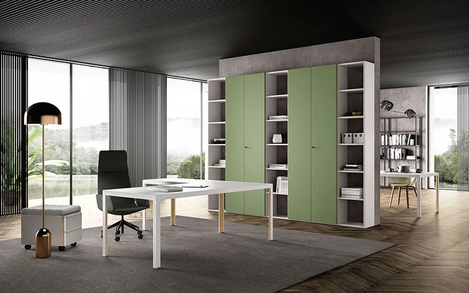 Parete di armadi laccati verde salvia con libreria a giorno in uno studio
