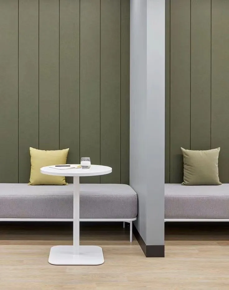Angolo relax con panche imbottite e boiserie verde